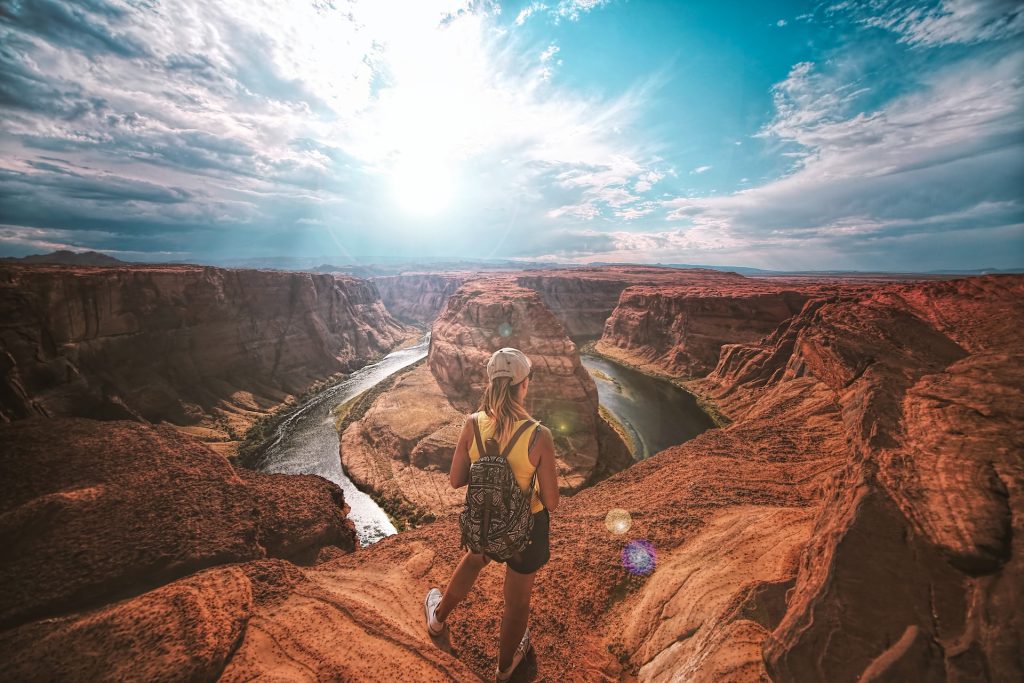 Woman standing on top of a rock at horsehoe bend