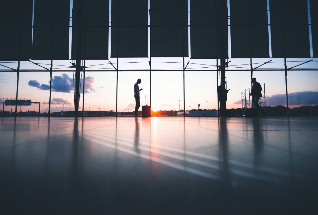 People in an airport terminal at sunset.