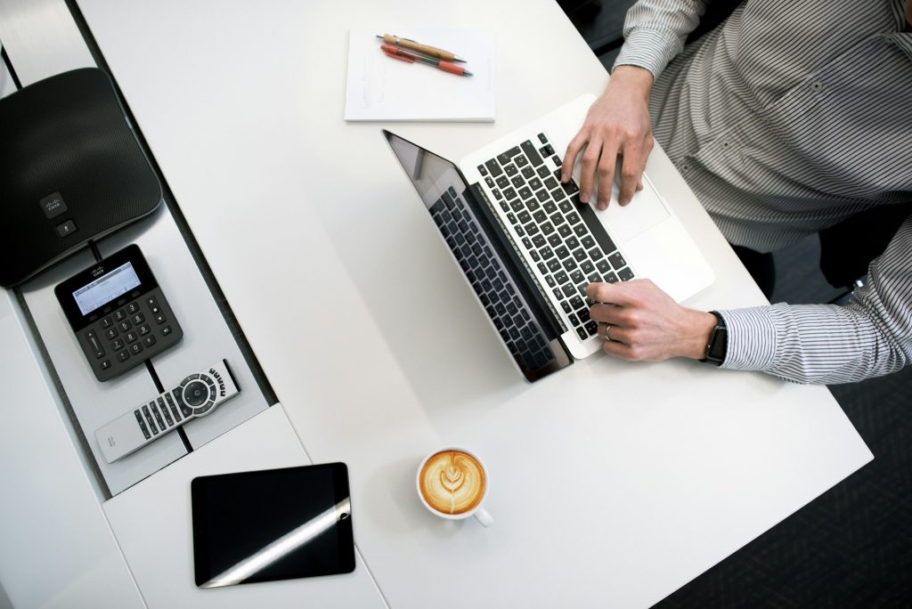 Aerial shot of a man sitting at a desk using a laptop